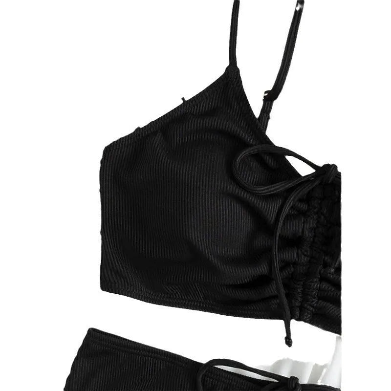 Black women's bikini swimsuit with sling top and high-waisted shorts on a white background