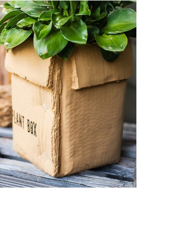 Cement brown paper box style floor planter with a drainage hole, shown in a Nordic indoor setting.