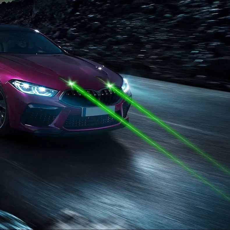 Black remote control vehicle strobe light with USB charging cable on a car bumper.