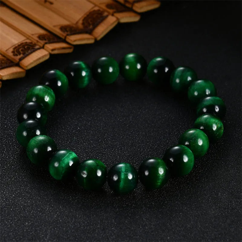 A polished green tiger eye stone bracelet with geometric beads, shown in various size options.
