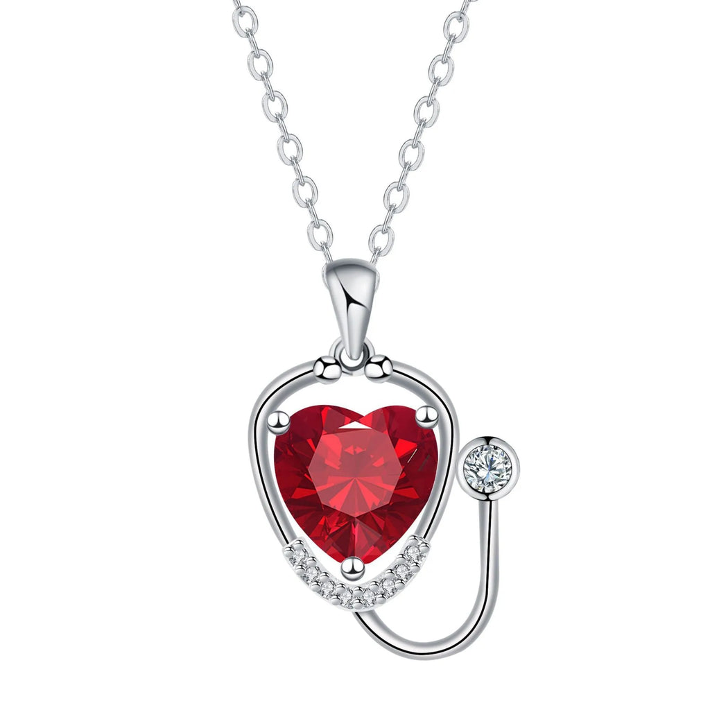 Women's fashion necklace with a copper wings cross stethoscope pendant featuring red diamond detail.