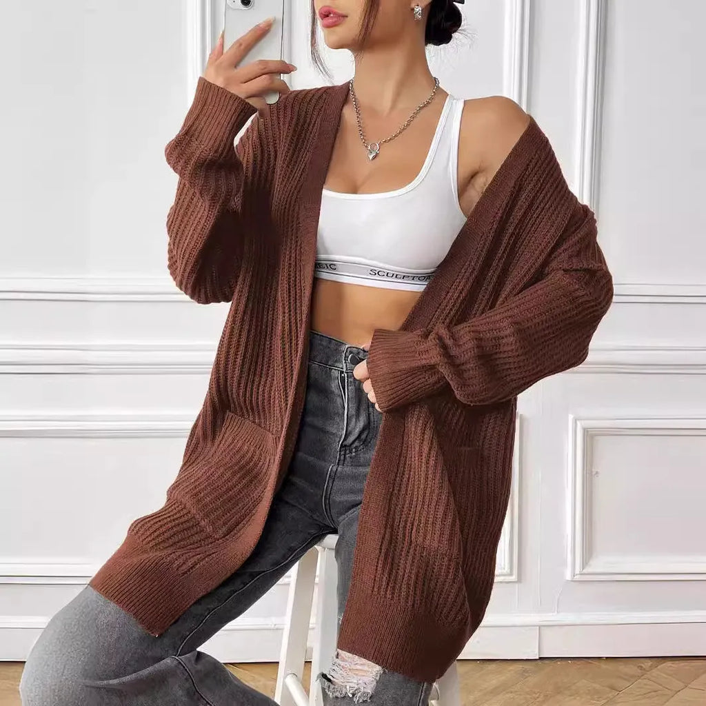 Women's dark green loose-fit mid-length acrylic cardigan sweater on a hanger.