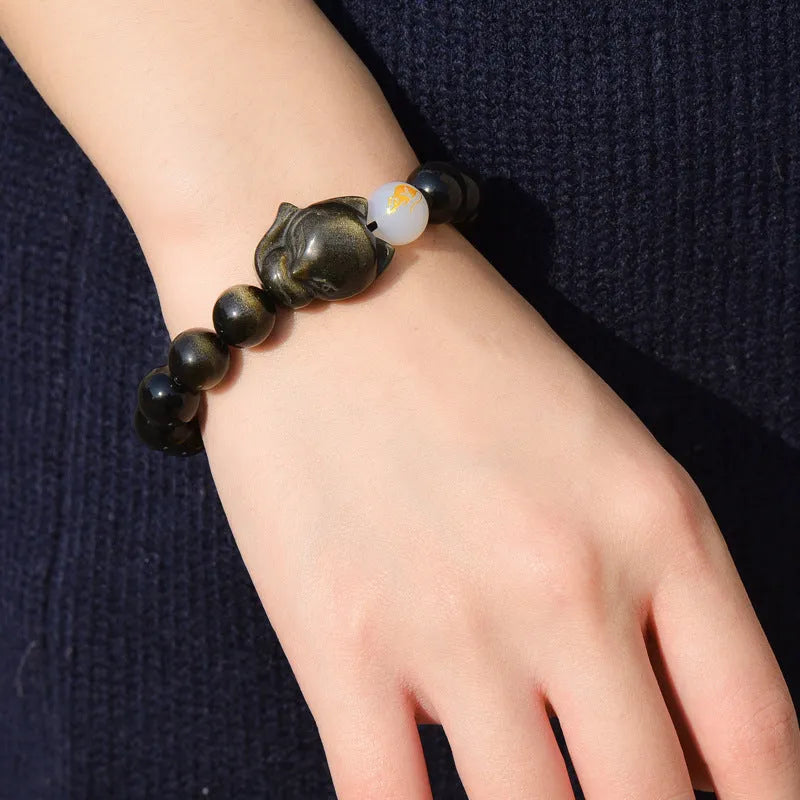 Adjustable obsidian zodiac bracelet with 10mm beads on a wrist.
