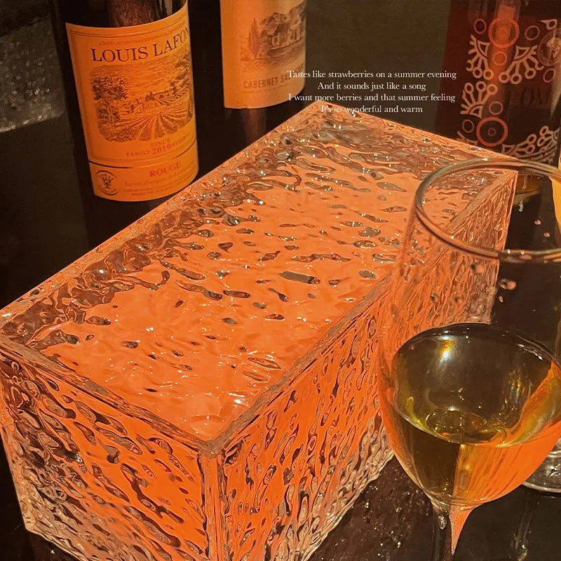 Geometric clear acrylic ice cube shaped night lamp with coloured LED light inside on a wooden table.
