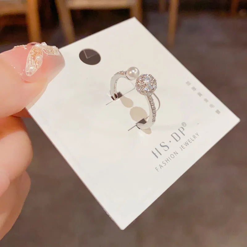 Adjustable open-end pearl ring with round zircon elements in gold plating