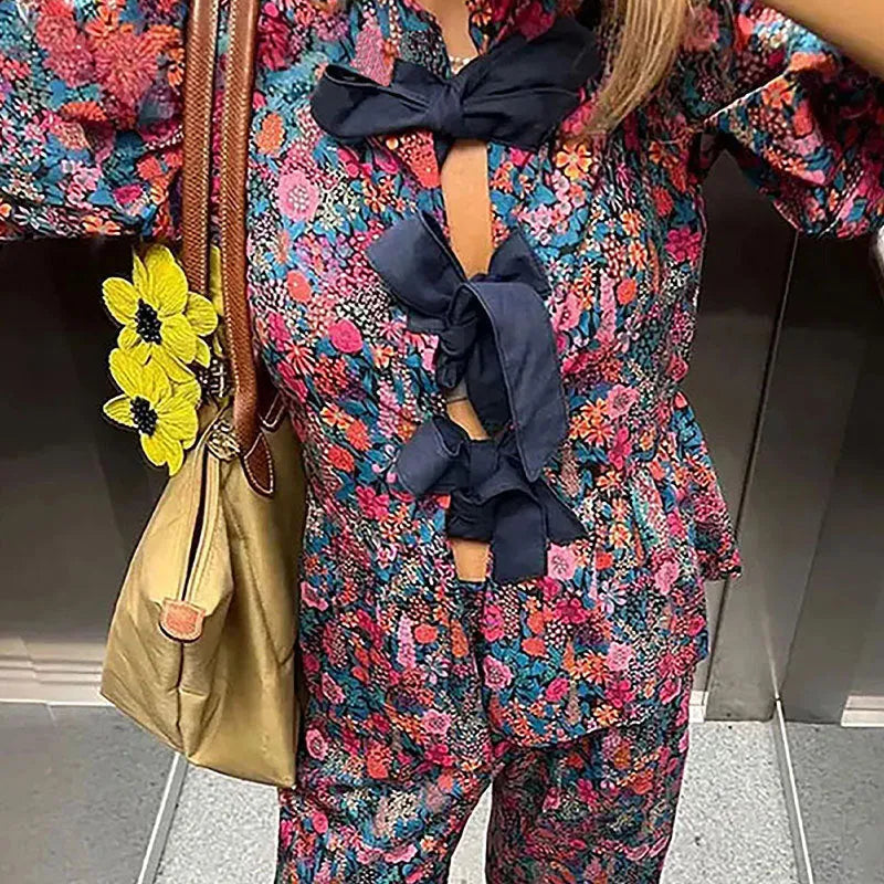 Women's floral print trouser suit co-ord set with puff sleeve top and matching trousers.