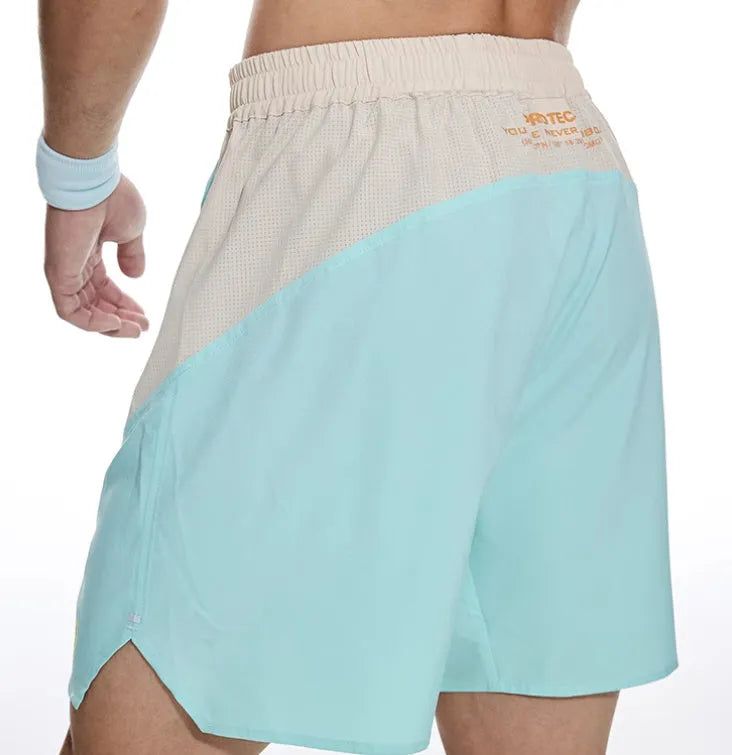 Man's loose grey workout shorts with elastic lace-up waistband, shown from side for gym use.