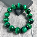 A polished green tiger eye stone bracelet with geometric beads, shown in various size options.