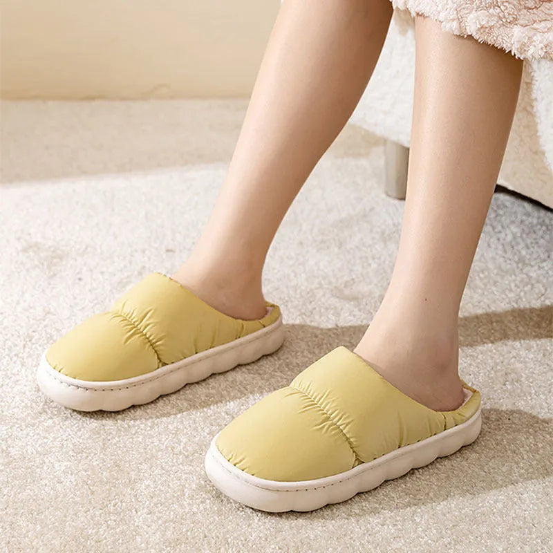 A pair of down cotton slippers with a thick rubber sole and artificial leather upper in a selected colour.