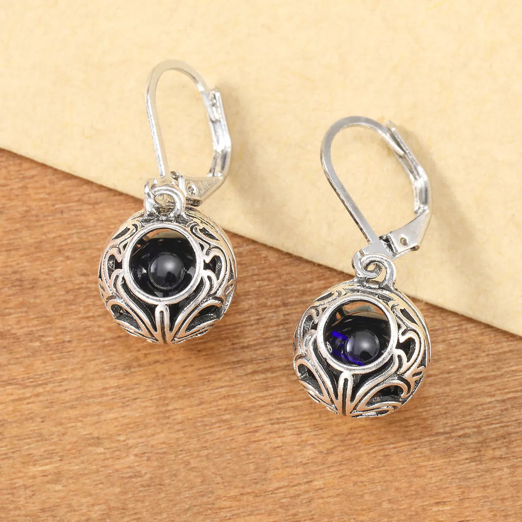 Silver geometric pendant earrings with vintage engraving and blue gemstone, shown from front view