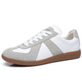White low-top retro unisex sneakers with round toe and lace-up front on a plain background.
