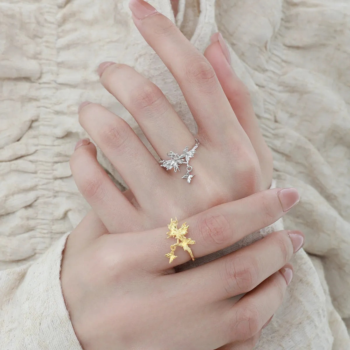 Adjustable silver butterfly ring with gold electroplating on model's finger