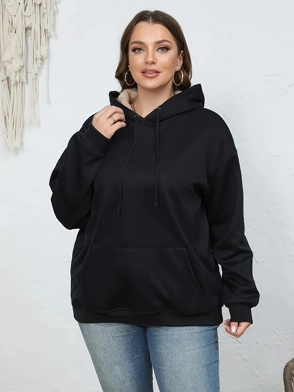 Women's loose black hooded sweater with pockets and a 3D textured pattern, long sleeves.