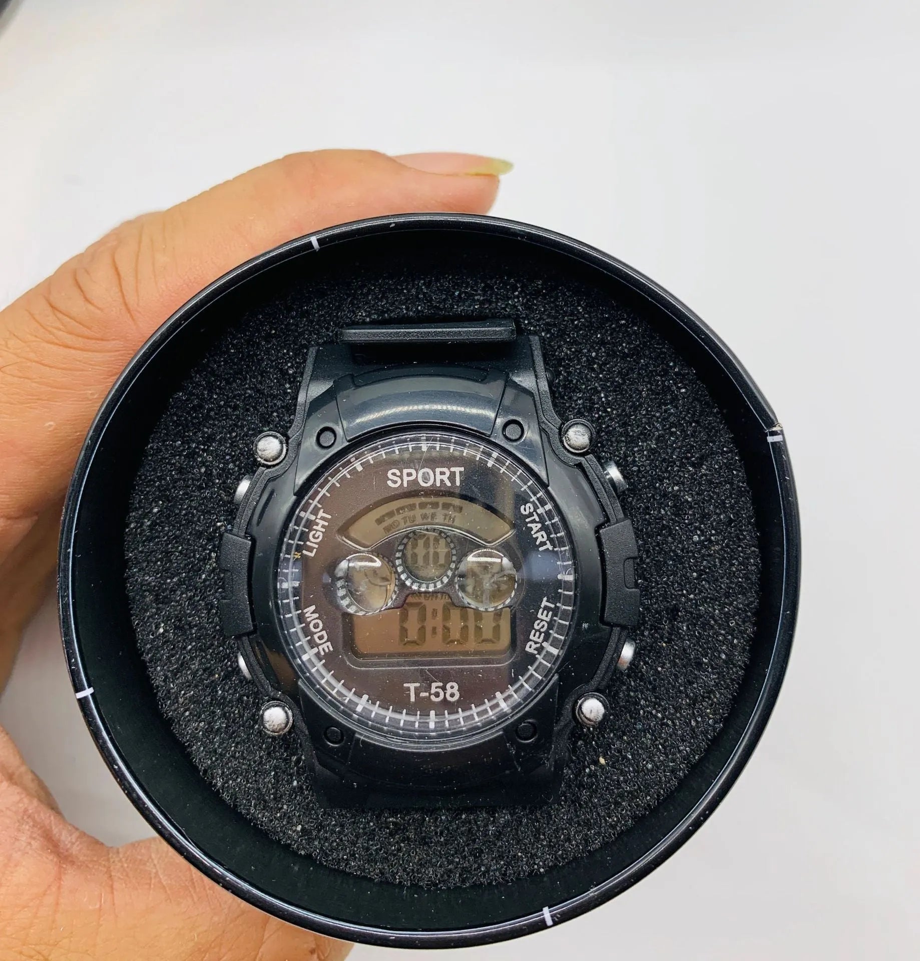 Children's digital sports watch with black plastic case, silicone strap, and luminous display showing time