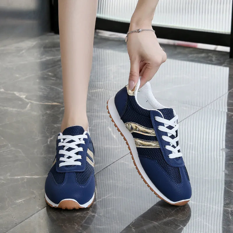Blue women's casual tennis shoes with a cross strap and white non-slip rubber sole.