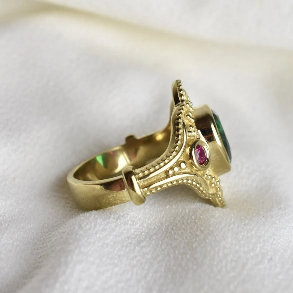 Gold-coloured geometric women's ring with an electroplated finish on a grey background.