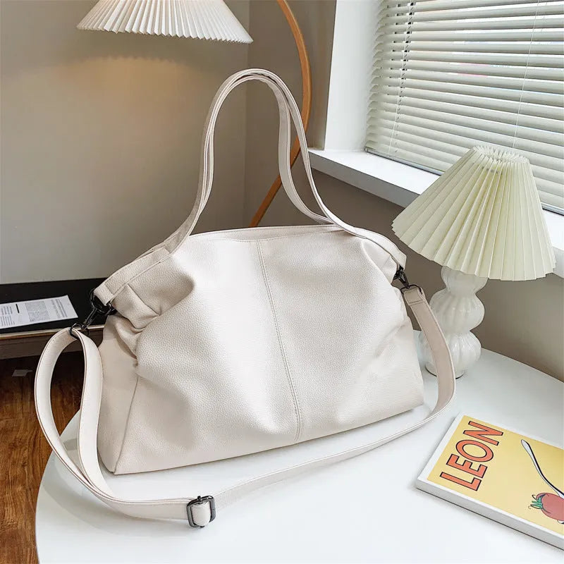Large soft PU messenger bag in khaki colour with a long shoulder strap, shown open to reveal inner phone pocket.