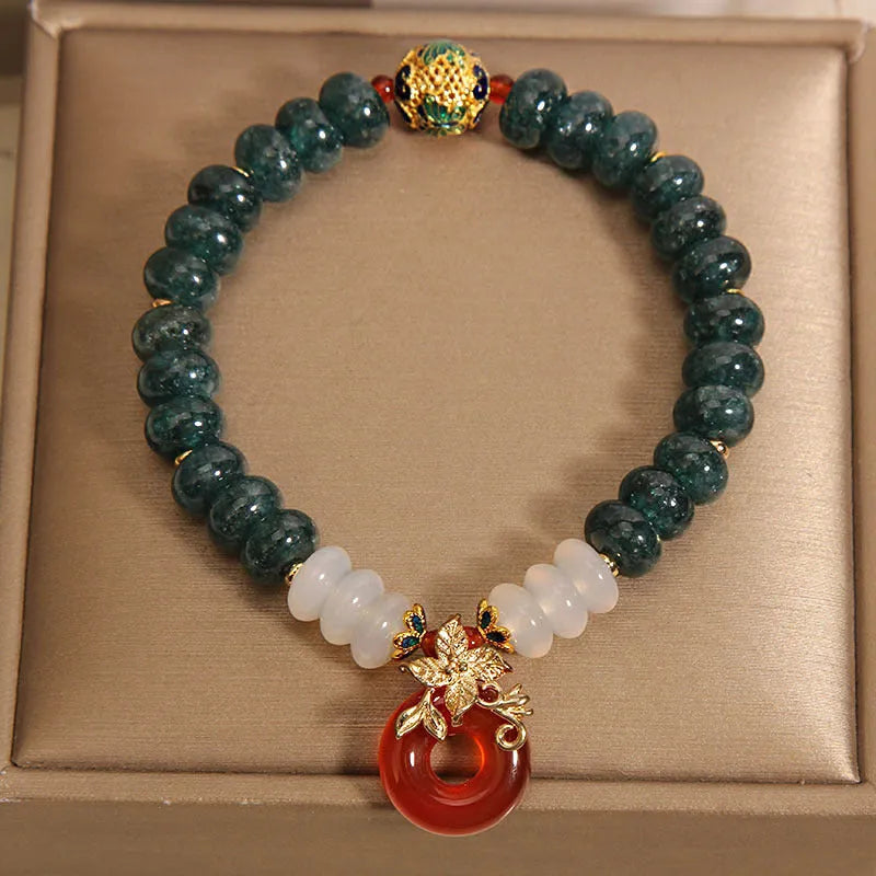 Blue water jade and red agate beaded bracelet with a peace symbol buckle clasp.