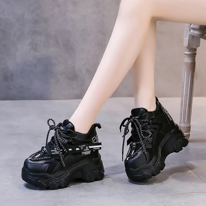 White women's low-top mesh sneakers with a black cross strap and a thick rubber platform sole.