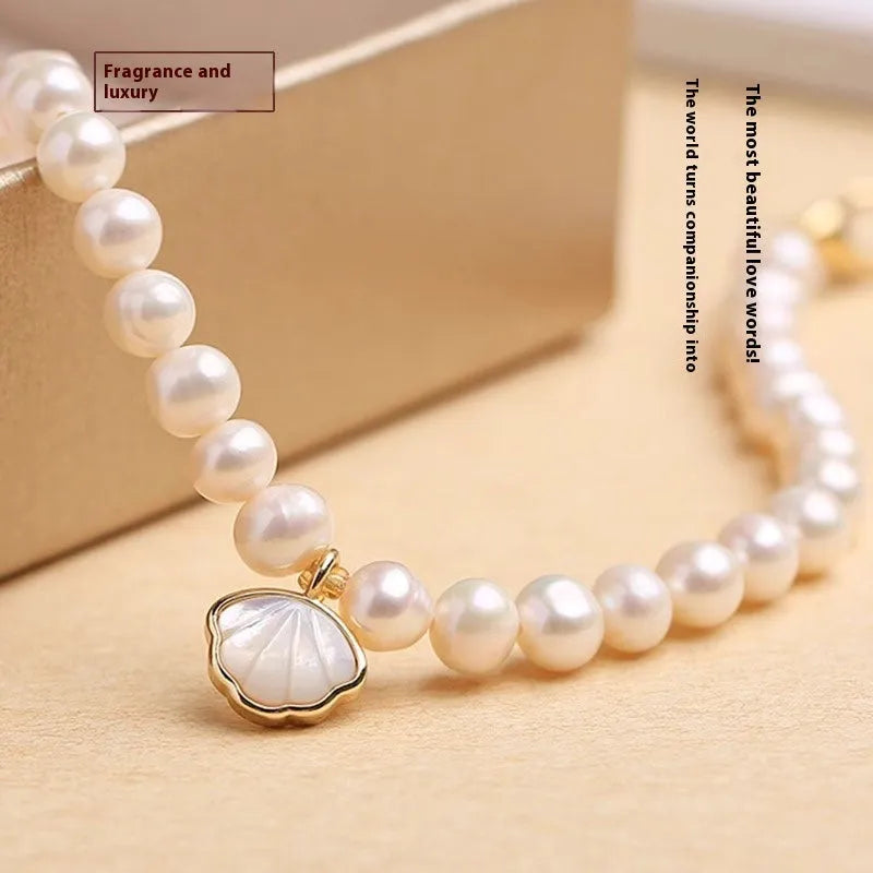 Women's fan-shaped freshwater pearl bracelet on wrist showing elastic string and extension chain options