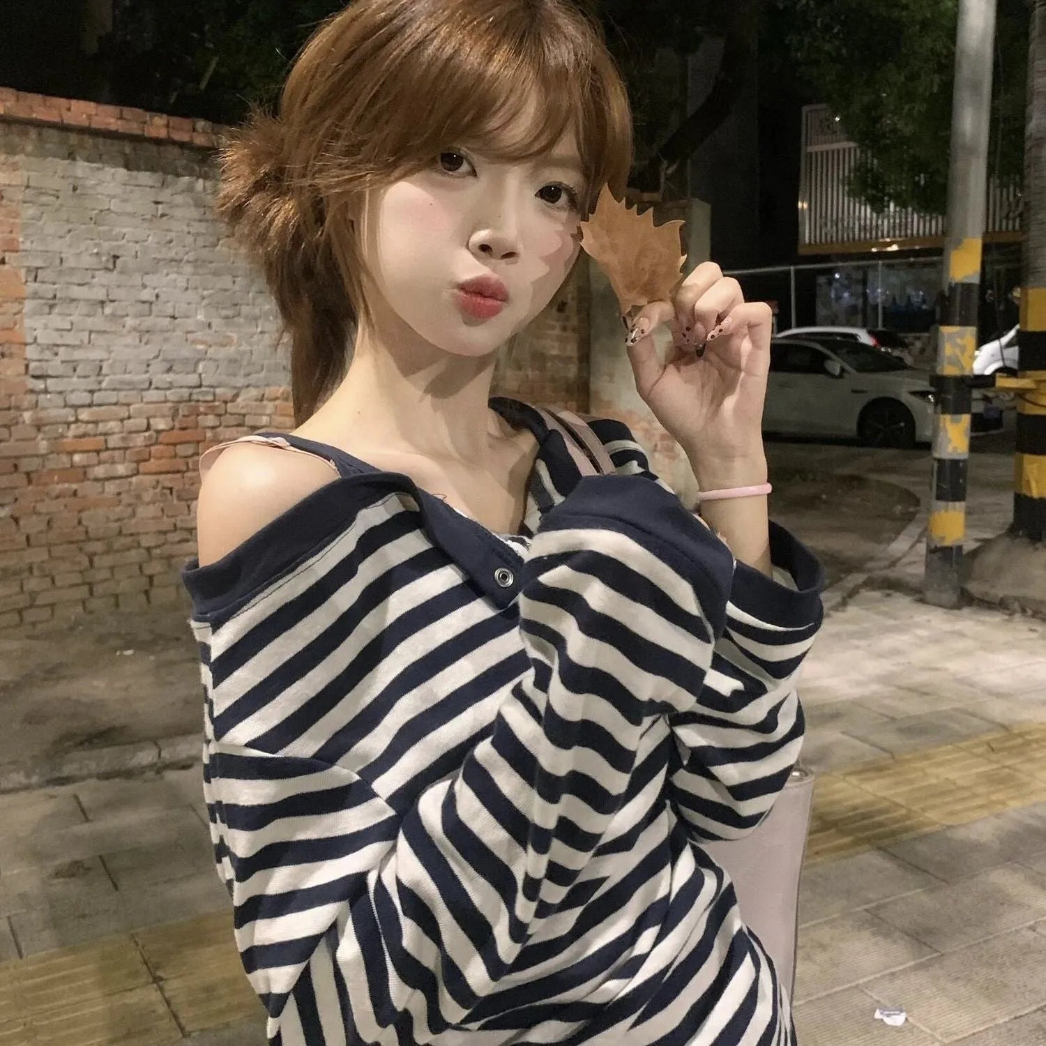 Dark blue women's long-sleeved oversized T-shirt with embroidery and striped detail on a hanger.