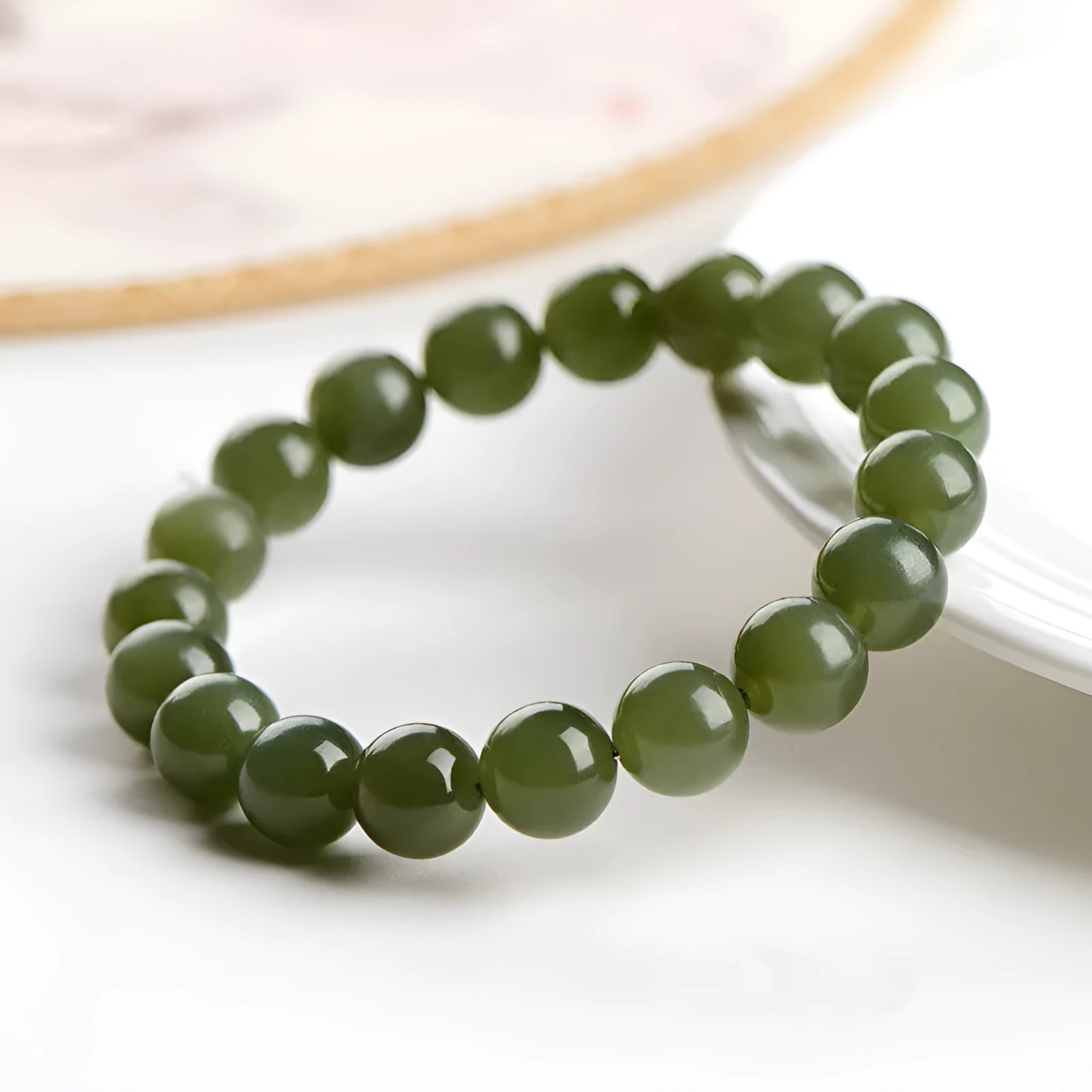 Polished Hetian jade ball bracelet in ice-like clear colour on a white background.