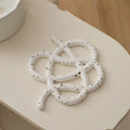 Ceramic heat proof mat in an irregular shape on a wooden table.