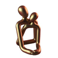 Modern white and gold resin couple statue for shelf or desk decor.