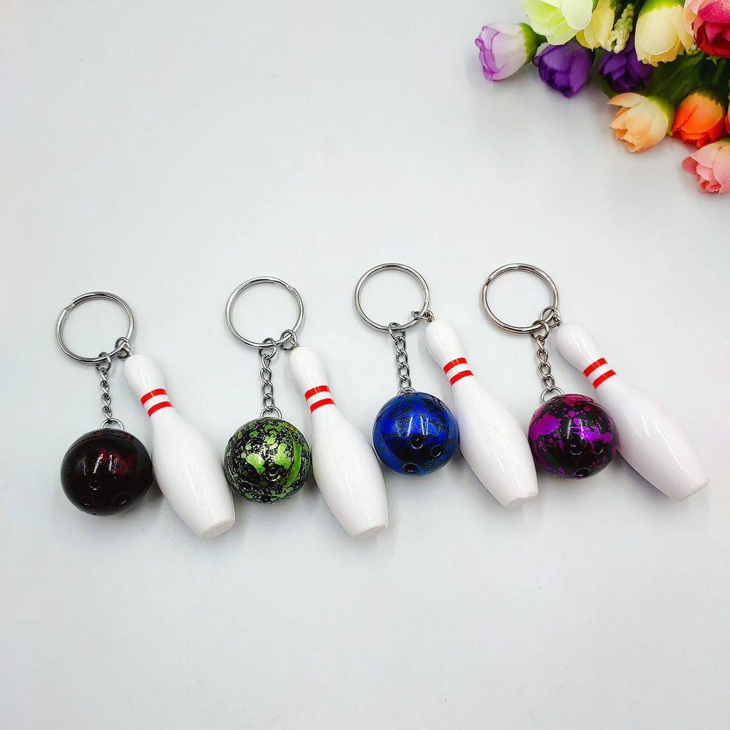 Miniature bowling ball keychain pendant in dark red, blue, purple, and green colours.