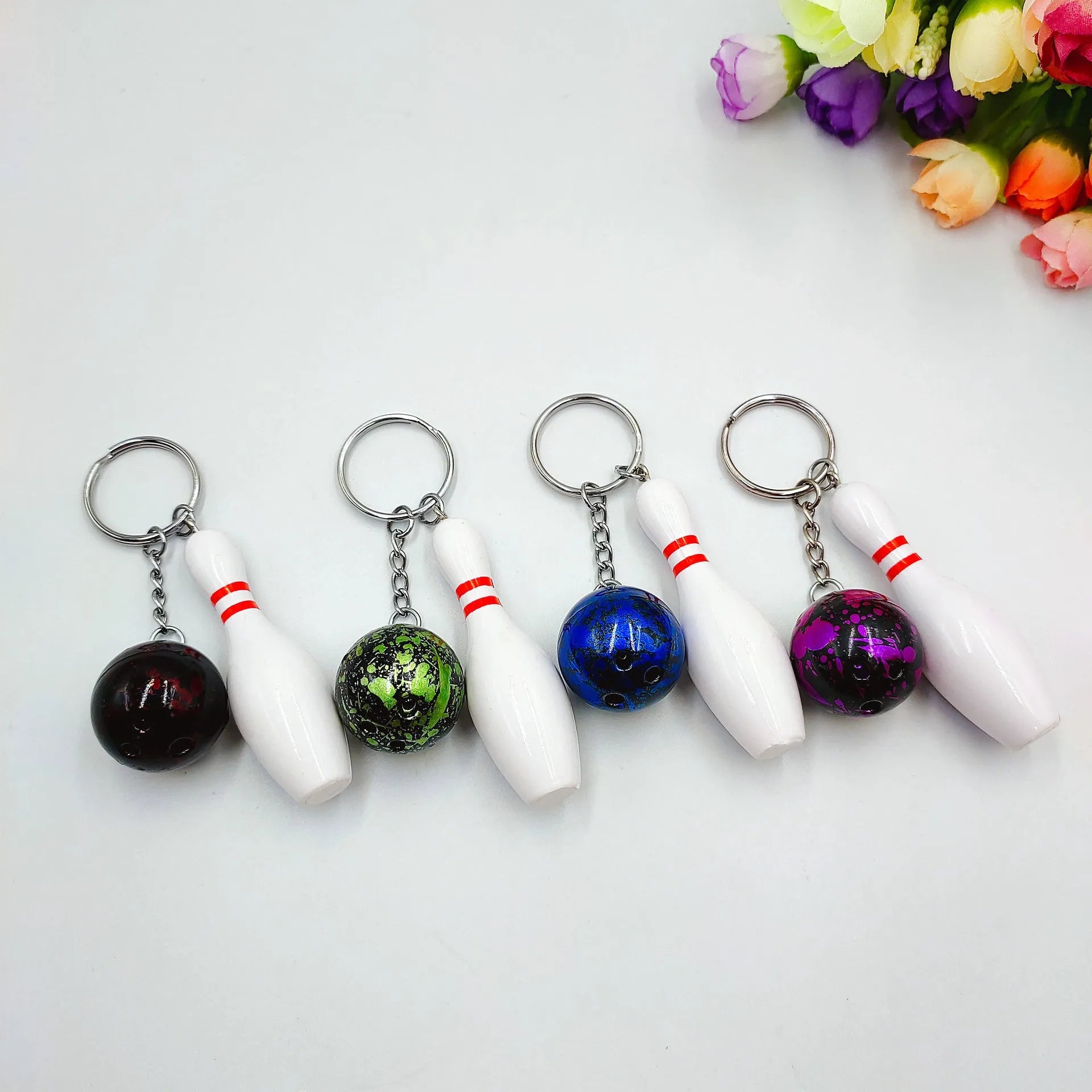 Miniature bowling ball keychain pendant in dark red, blue, purple, and green colours.