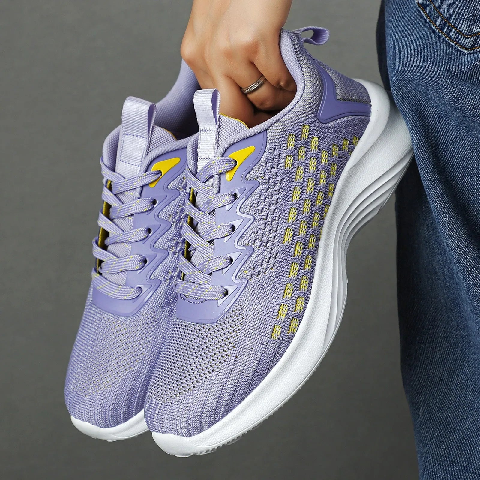 Women's lavender purple Flyknit running shoes with striped pattern and mesh upper on a white background.