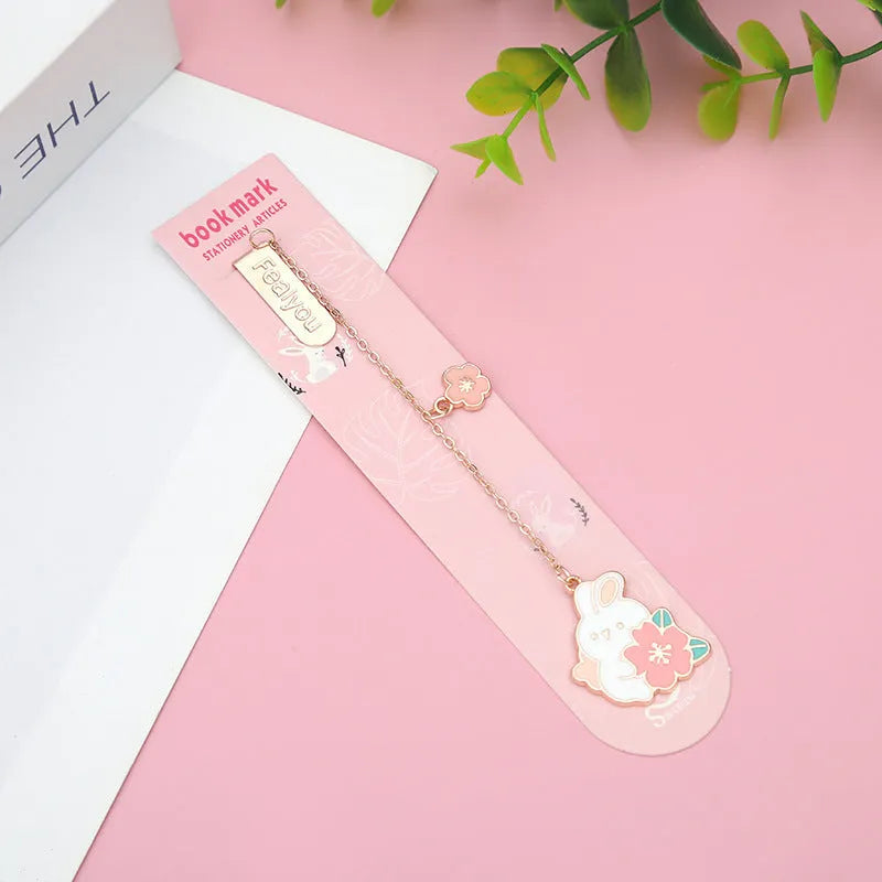 Small metal pendant bookmark with cartoon Sakura cat or cherry blossom rabbit illustration.