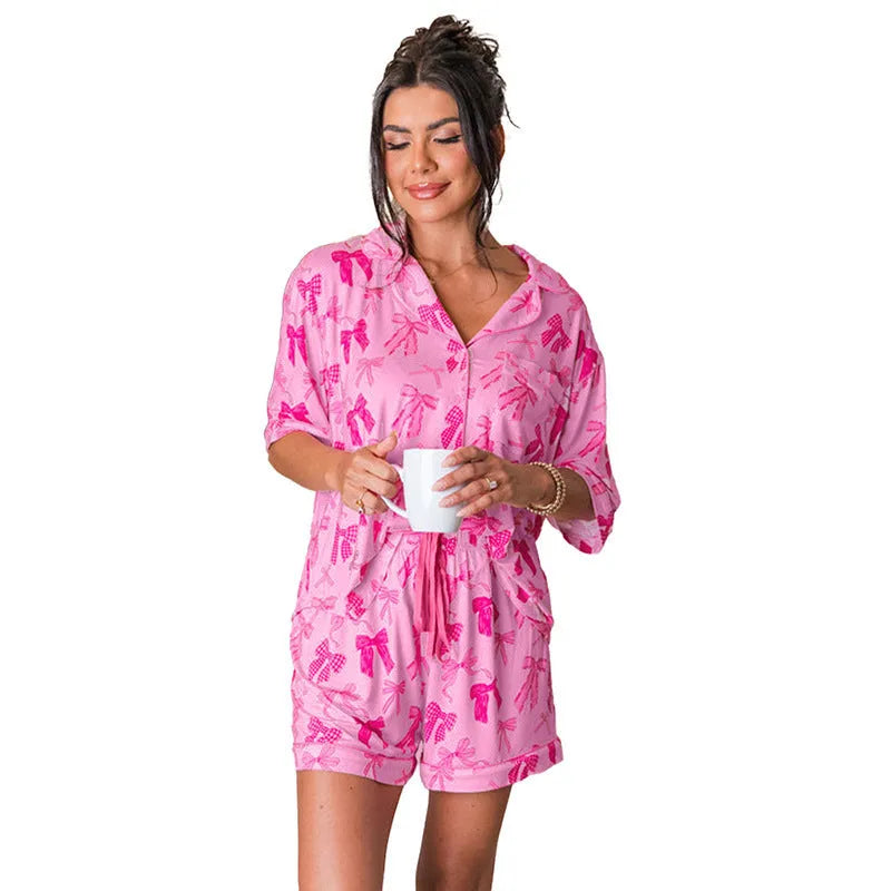 Pink bow print women's two-piece pajama set with matching top and trousers.