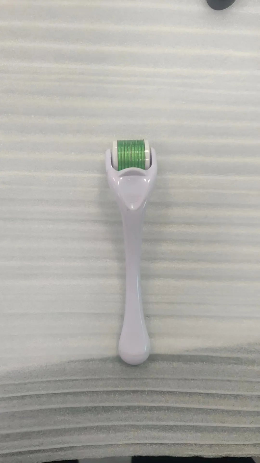 Sterile 540 micro needle derma roller showing handle and needle wheel in assorted colours.