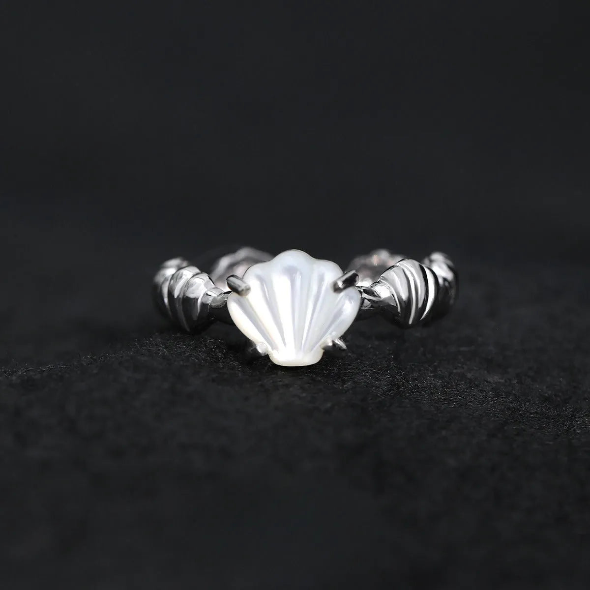 Adjustable silver women's ring with shell design in shell white or tiger eye finish.