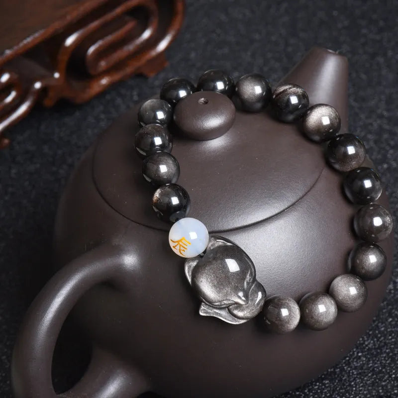 Adjustable obsidian zodiac bracelet with 10mm beads on a wrist.