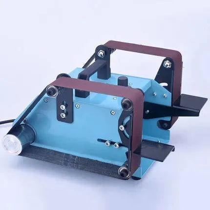 Blue desktop dual-axis belt sander with abrasive belt, variable speed switch, and compact metal housing.