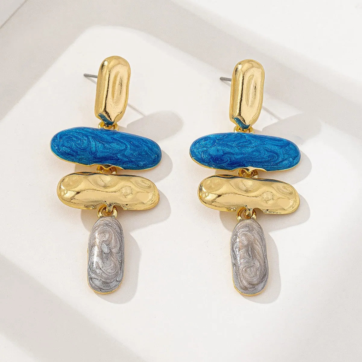 A pair of geometric stud earrings with a multicolour electroplated finish on a zinc alloy base.