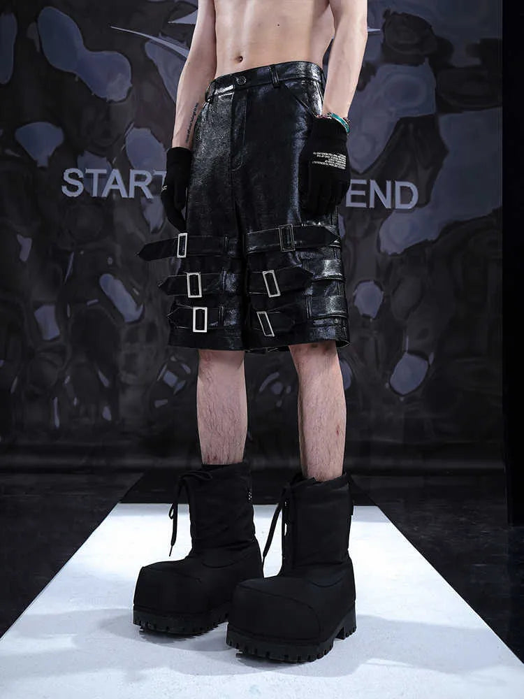 Men's black PU leather cropped shorts on a hanger, showing low waist and casual fit.