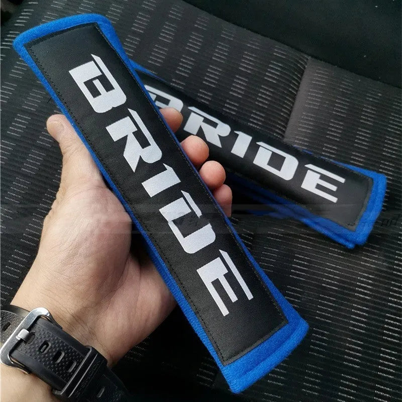 Cotton sponge cloth car seat belt shoulder pads in black, blue, and red colours, showing embroidered weaving detail.