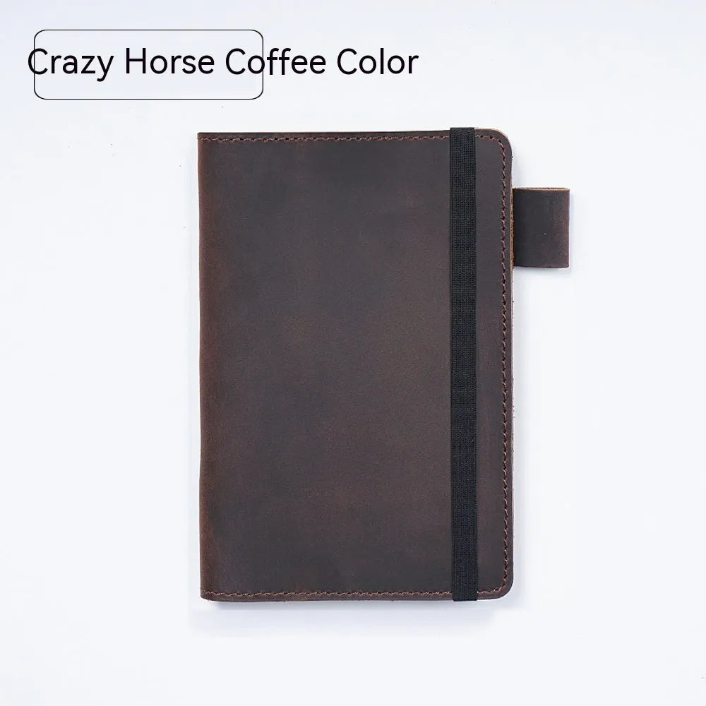Handmade notebook with cowhide cover open on a table, showing 100 gsm wood-free paper inside