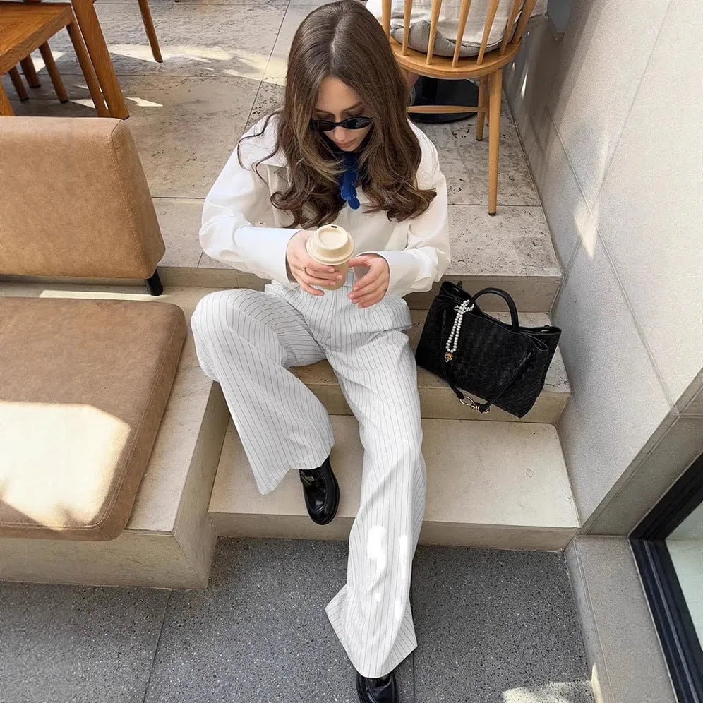 White striped wide-leg women's trousers with front zip fastening on hanger