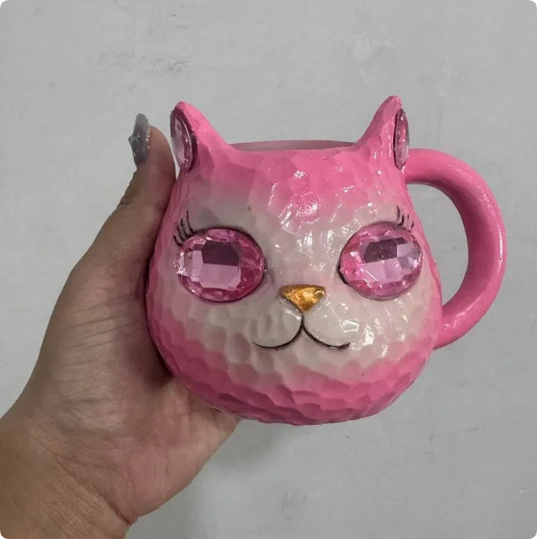 Decorative resin cat cup paperweight in American crafts style, shown in purple, green, blue, and pink colour options.