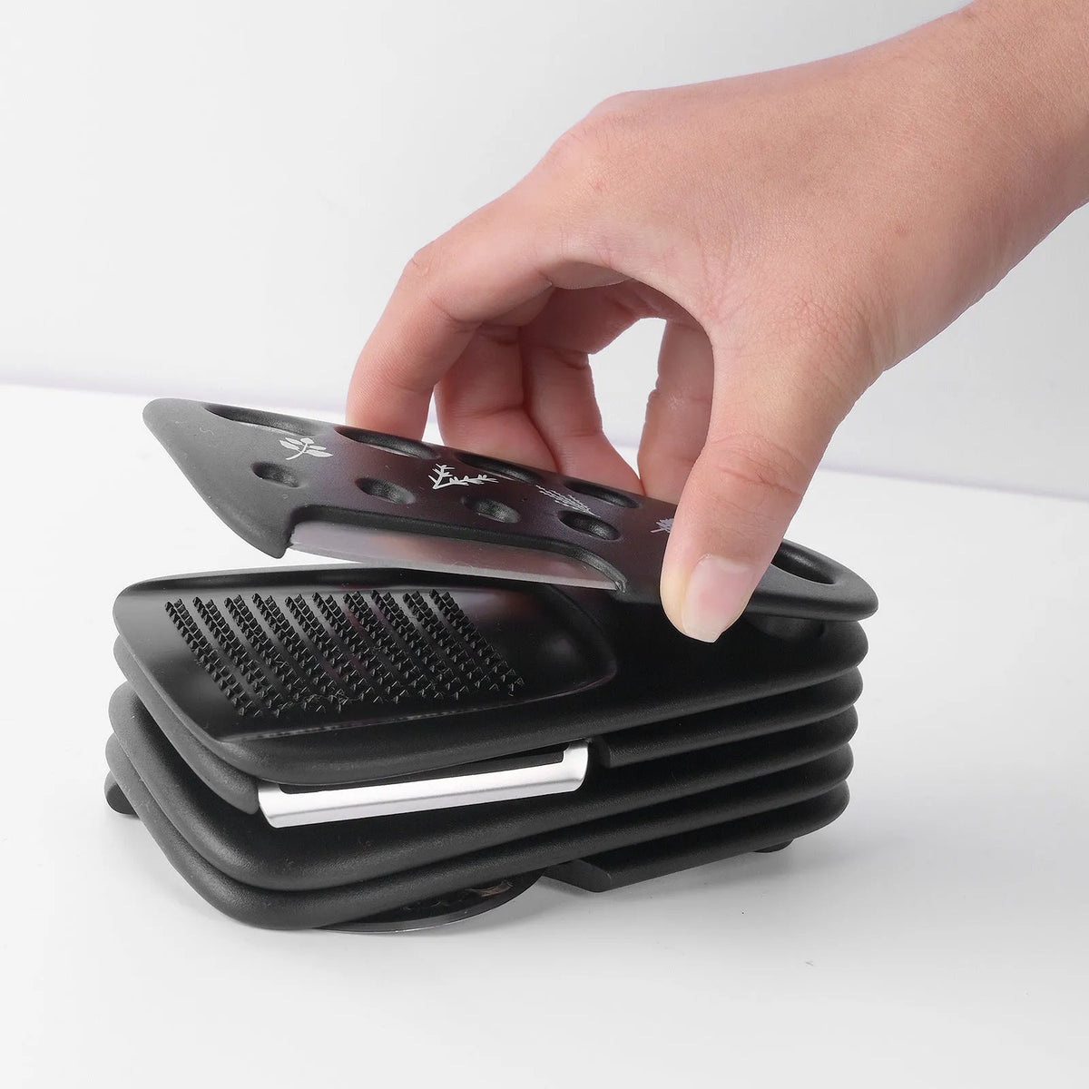 Six stackable kitchen tools and a cleaning brush in a modern colour box.