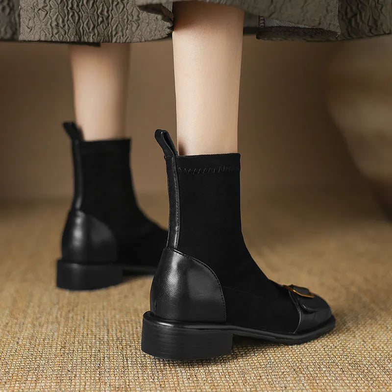A pair of black women's lace-up Martin boots with a round toe and low rubber sole on a white background.