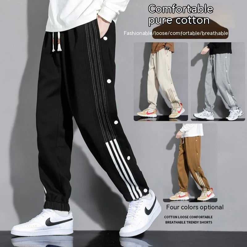 Man wearing black high-waisted, loose, ankle-tied sweatpants with a belt, showing the drawstring waist.