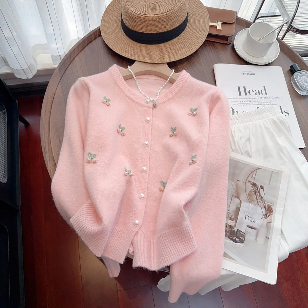 Pink cashmere blend cardigan coat with beaded details on a hanger