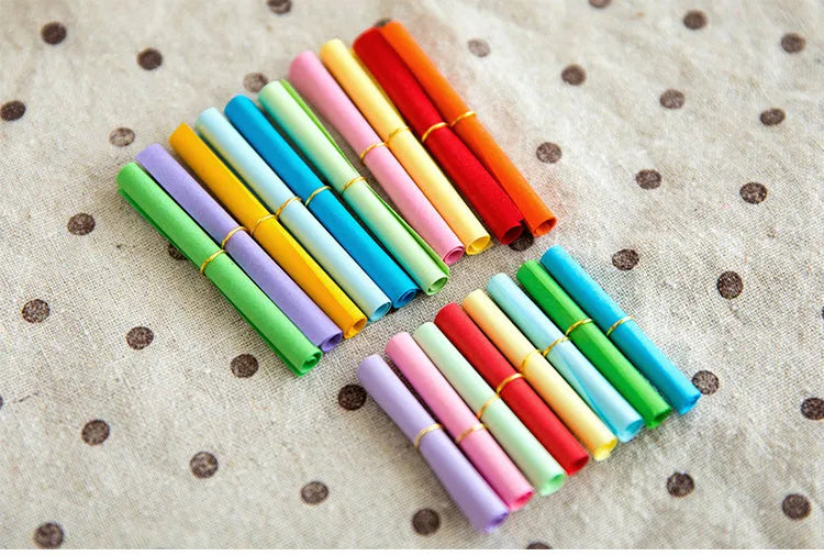 Assorted colour mini paper scrolls with eyelets for drift bottle messages and crafts.