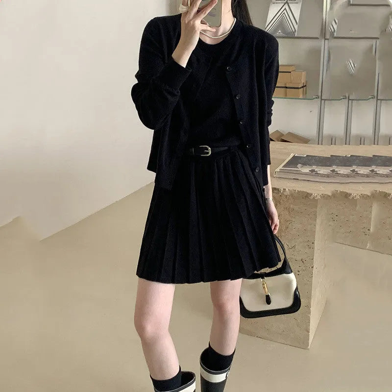 Women's grey knitted cardigan and pleated vest skirt two-piece set with a belt.