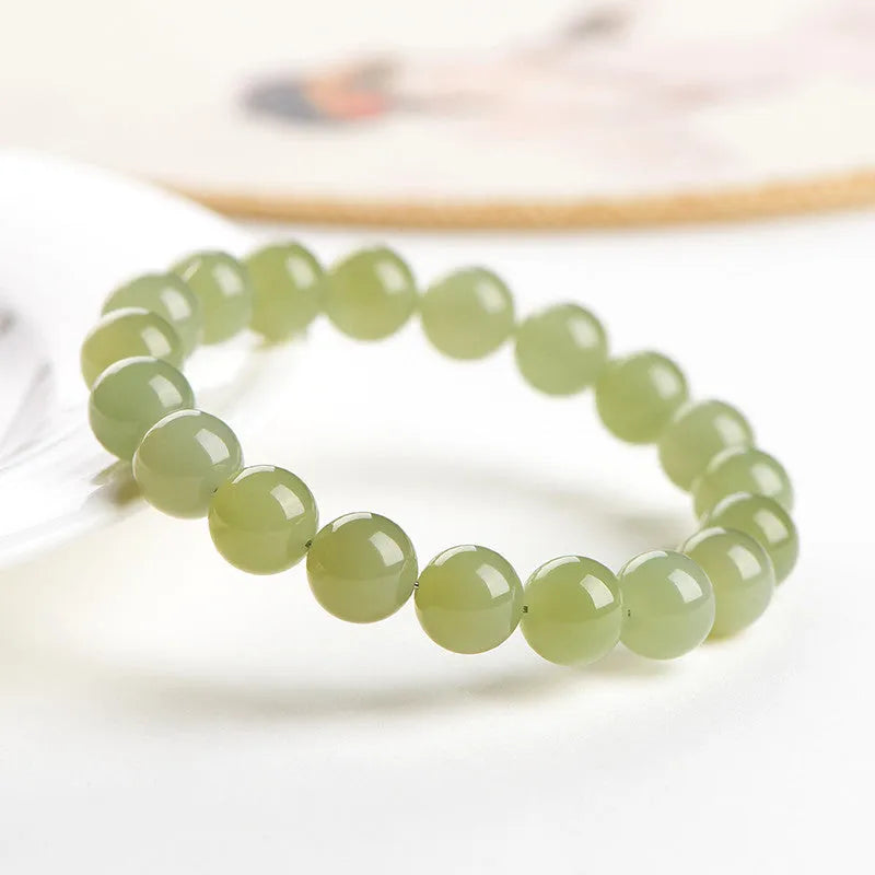 Polished Hetian jade ball bracelet in ice-like clear colour on a white background.